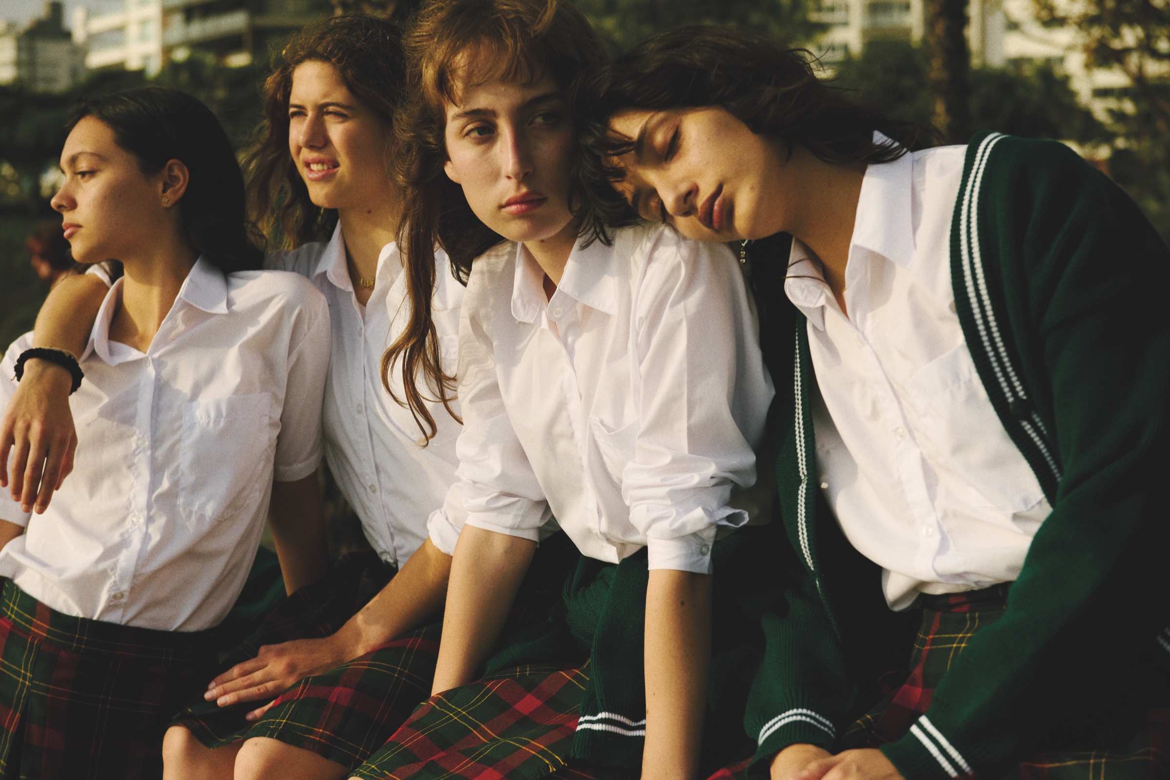 Four students sit closely together in late-afternoon light.