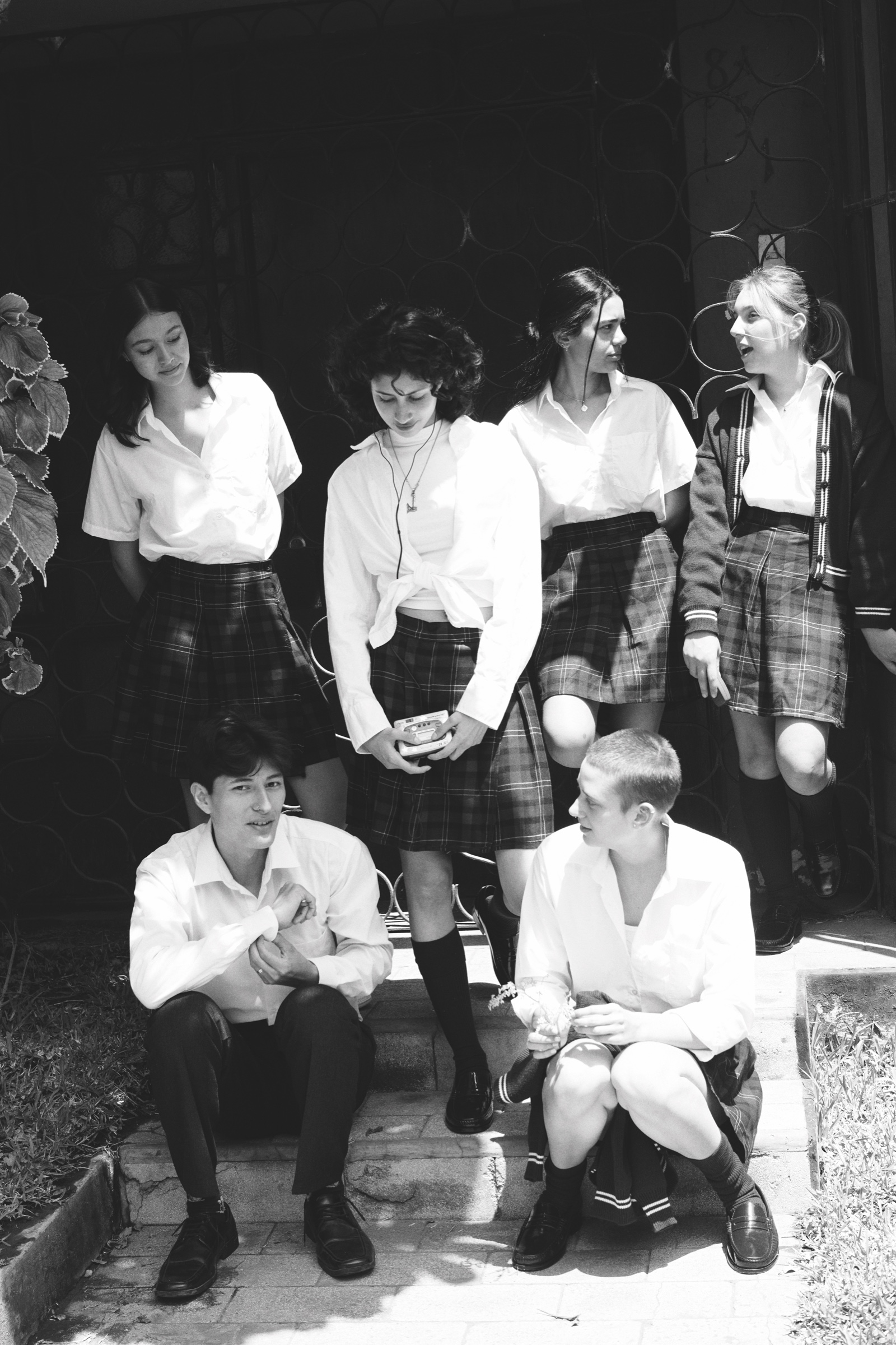 Students gather on steps in a black-and-white photograph.